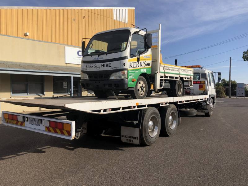 Small commercial hire truck loaded on a tilt-tray tow truck
